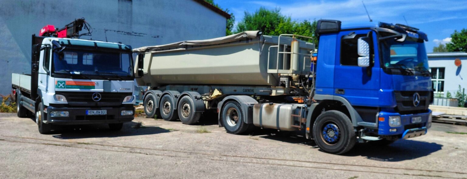 Two large Mercedes trucks with a long multi-axle trailer in an industrial yard.] , but fix quotes
